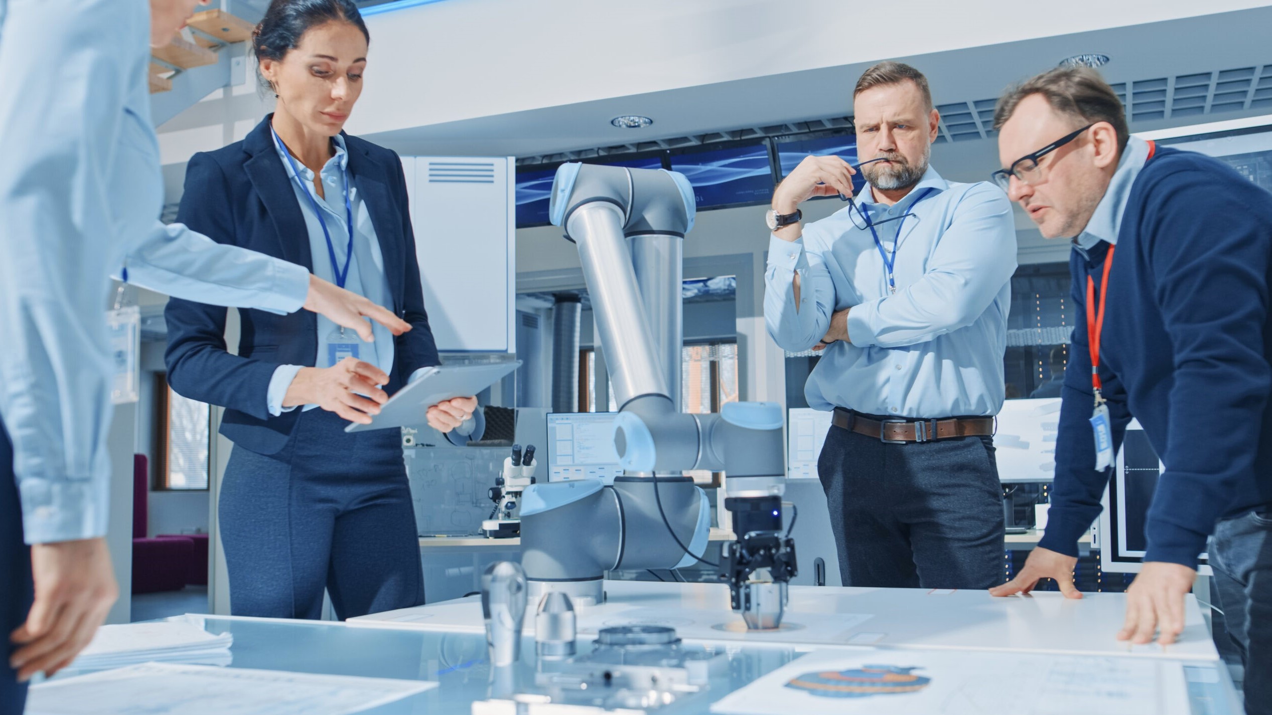 Scientists around a table with robot arm